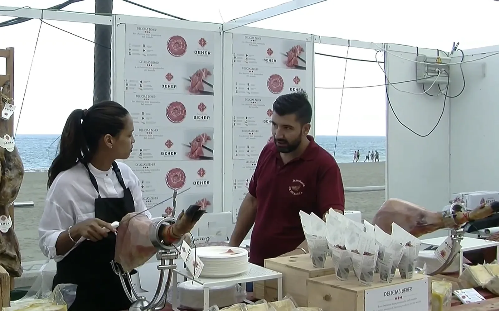 A carver and an exhibitor at a stand beside the beach, 2017