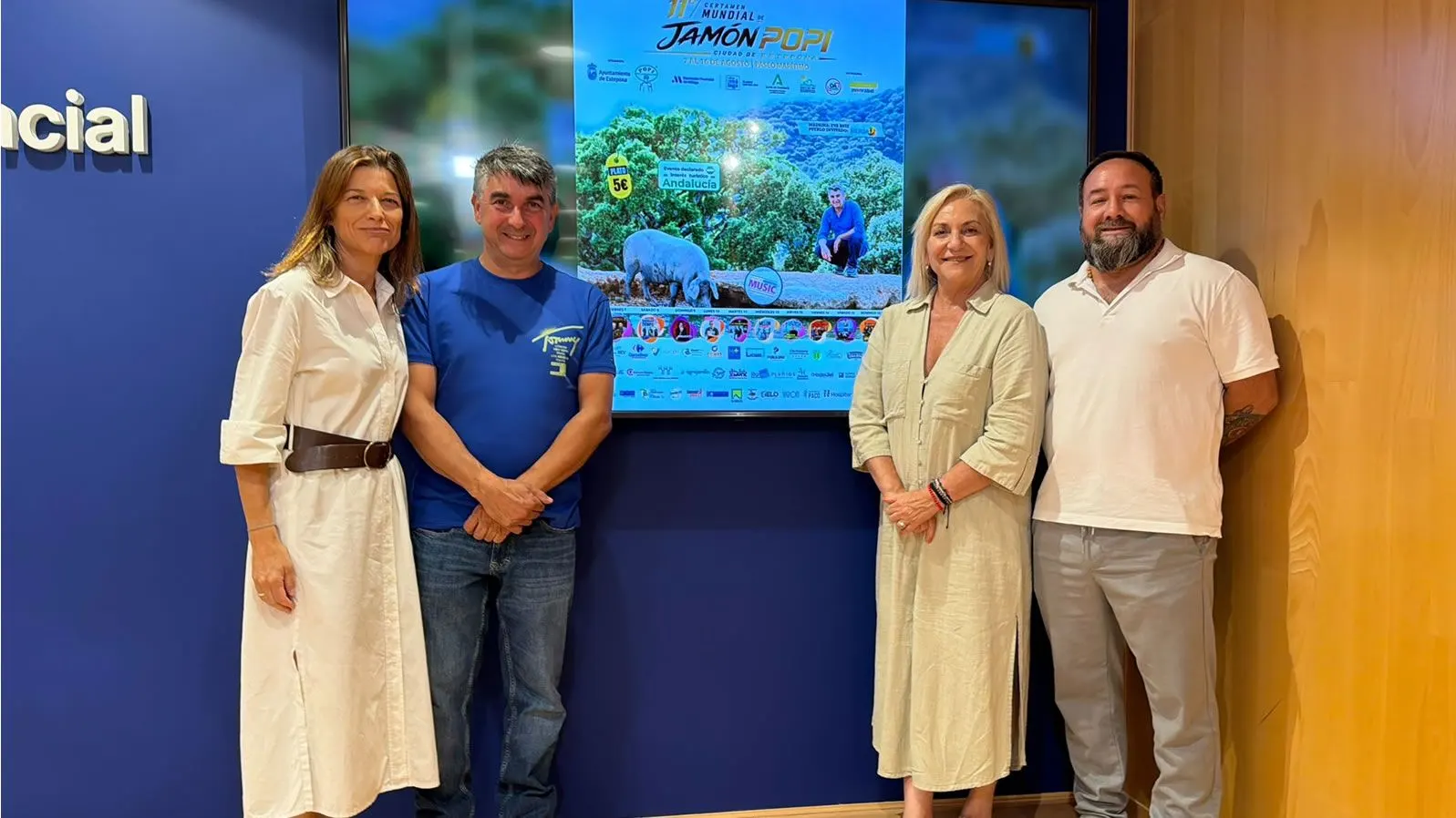 Popi beside the poster of the eleventh edition at the presentation held at the Diputación de Málaga, 2026